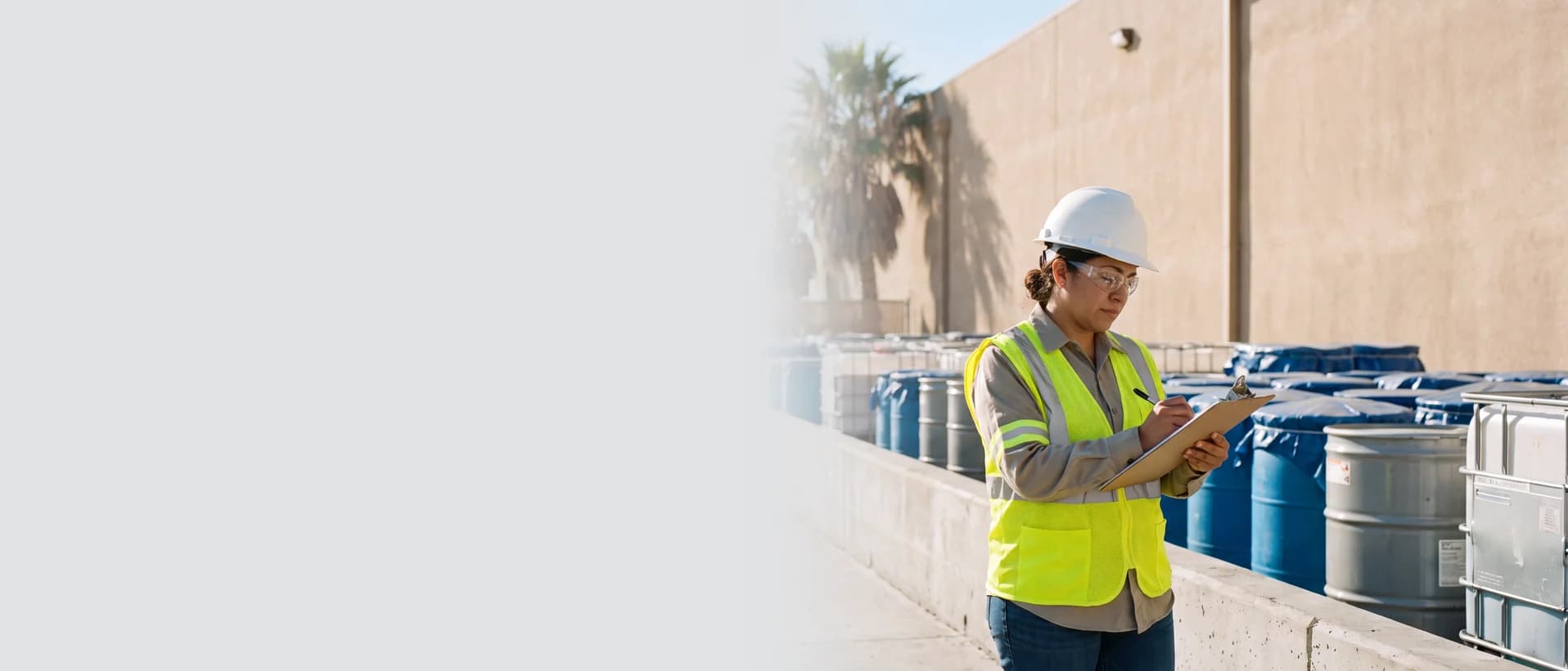 California hazardous waste employee inspecting storage containers