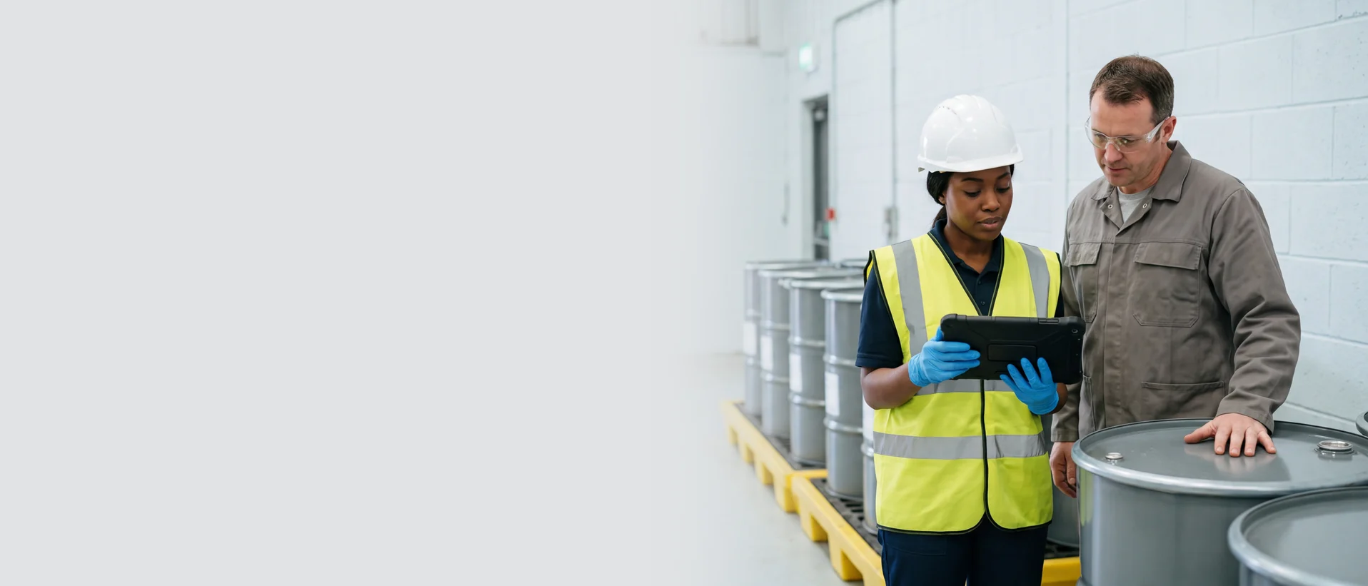 Hazardous waste personnel reviewing container records in a facility